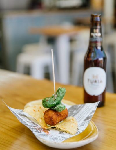 Qmcomo: Croqueta de pulpo y escalibada aliñada con aceite de diania